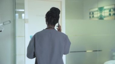 Ofisinde steteskopuyla gezen genç bir tıp subayı.