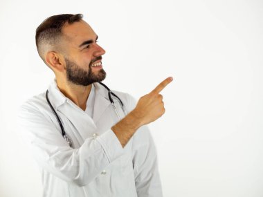 Genç erkek doktor gülümseyerek sağı işaret ediyor. Beyaz arkaplanda izole