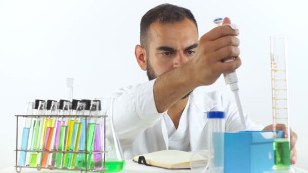 年轻的男性科学家用微量器从烧杯中提取液体样本 — 图库视频影像