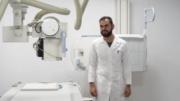 Bir Röntgen Odasında Genç Bir Erkek Doktor Kameraya Bakarken Kollarını — Stok video