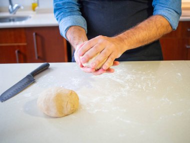 young man kneading a wheat flour dough clipart