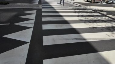 Beyaz bastonuyla karşıdan karşıya geçen kör bir adam dikkatlice ilerliyor..