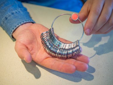 Mücevher alışverişi: Yüzük boyunu gösteren bir adam