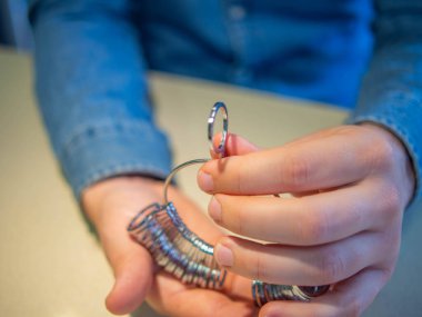 Yüzük ölçüm aracı kullanan bir adamın yakın plan görüntüsü.