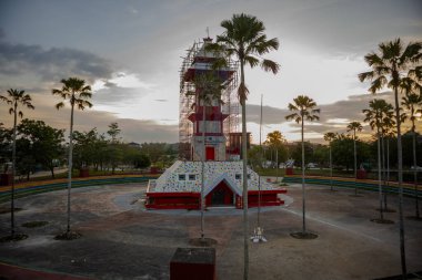 Güneş, Tenggarong şehir parkında palmiye ağaçlarıyla çevrili bir binada batıyor..