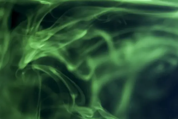 在水中溶解的绿色液体形成了一个抽象的形状 — 图库照片
