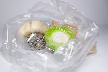 Beyaz arka planda plastik poşetlerde çeşitli geleneksel pazar atıştırmalıkları.