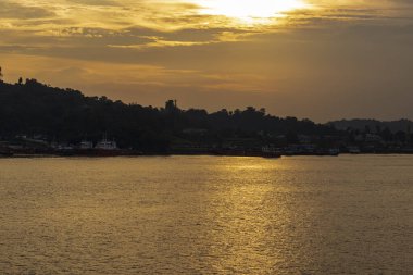 Güneş battığında Mahakam Nehri manzarası nehir etrafındaki gemi ve binalarla süslenir..