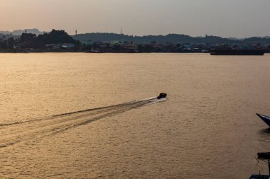 Güneş battığında Mahakam Nehri manzarası nehir etrafındaki gemi ve binalarla süslenir..