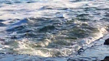 View of the blue waves with foam on the sea