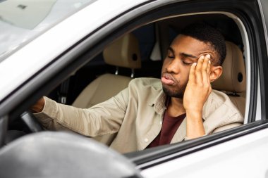 Arabanın sürücü koltuğunda oturan stresli adam ön cama bakar ve düşünür. Yüksek kalite fotoğraf
