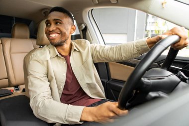 Mutlu sahip. Yakışıklı, sakallı, olgun bir adam yeni aldığı arabasında rahatça oturup pencereden dışarı bakıp neşeyle gülümsüyor. Yüksek kalite fotoğraf