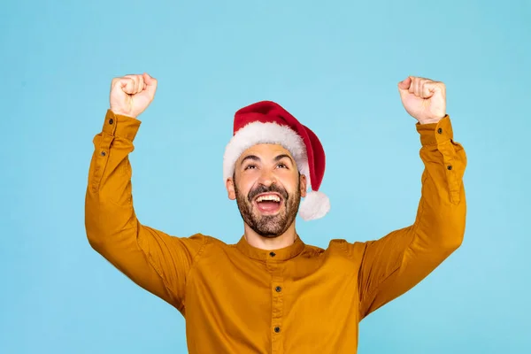 Noel Şapkalı Neşeli Adam Mavi Stüdyo Arka Planında Mutluluğu Gösteriyor — Stok fotoğraf