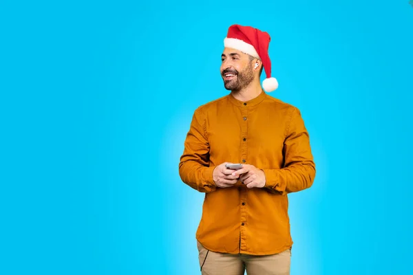 스마트폰을 크리스마스 모자를 남자가 복제품 스튜디오 파노라마를 봅니다 고품질 — 스톡 사진