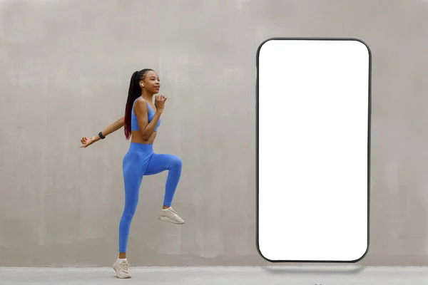 在灰色背景的空白白屏大型智能手机前健身的女运动员展示了新的酷应用程序 免费复制的空间模型 网站设计横幅 高质量的照片 — 图库照片