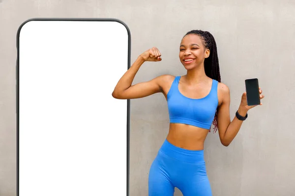 Svart Kvinna Tittar Kameran Medan Flexing Biceps Och Hålla Telefonen — Stockfoto