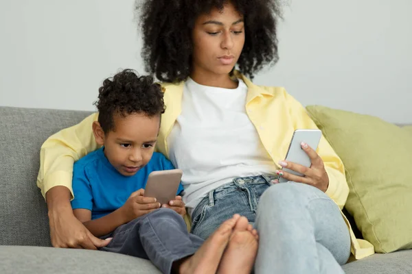 African American Mother Young Son Relaxing Smartphone Home Browsing Internet — Stock Photo, Image