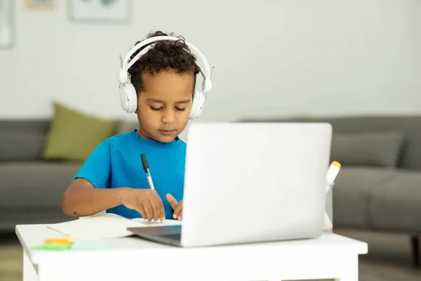 Busy Boy Writes Information His Paper Notebook Online Lesson Laptop — Stock Photo, Image