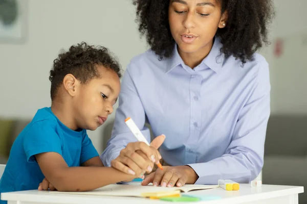 Female Infant School Teacher Working One One Young Schoolboy Sitting — Stockfoto