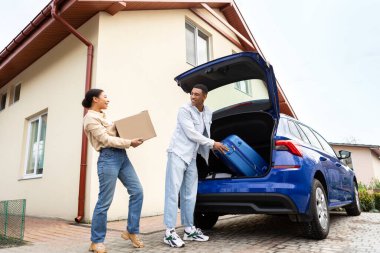 Mutlu Afro-Amerikan çifti tatile çıkıyor, bagajlarını seyahat çantalarıyla dolduruyor, karı koca bagajlarını açıp bagajlarını yerleştiriyor.