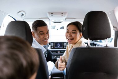 Üç çocuklu Afro-Amerikan ailesinin yeni arabalarında oturup çocuklara baktıkları ve birlikte yaz tatilinin tadını çıkardıkları sahneler.