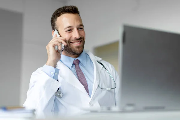 Alegre Médico Masculino Hablando Por Teléfono Celular Utilizando Ordenador Portátil — Foto de Stock