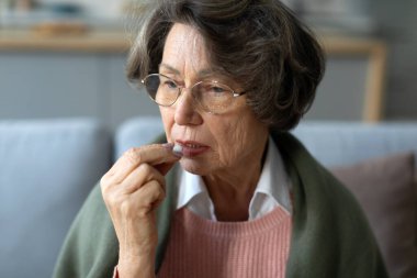 Yaşlı kadın hap alıyor, yaşlı kadın ilaçla el ele tutuşuyor. Tedavi, ilaç, ilaç, hap, vitamin, takviye kavramı