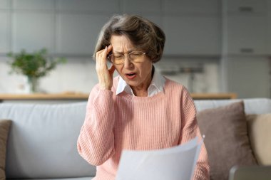 Belge okuyan yaşlı bir kadın ve evde stresli kötü haberler alan yaşlı bir bayan, mektupla şoka girmiş, kafaya dokunmuş, olumsuz duygularla baş etmeye çalışmış.