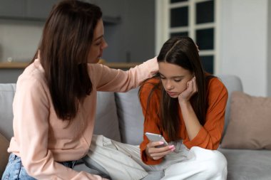 Sevgi dolu bir anne üzgün bir genç kızı rahatlatır ve geçindirirken çocuk telefona bakar, anne depresyondaki kızının ayrılığı atlatmasına yardım eder.