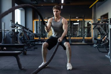Fitness, savaş halatları ve spor salonunda güç, kardiyo ve idman yapan genç adam, spor kulübünde sağlık ve sağlık ekipmanları ile antrenman