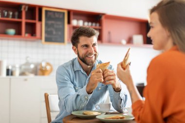 Heyecanlı eşler kahve içip kafeteryada veya kafede sandviç yiyorlar, keyifli sohbetler ediyorlar ve gülümsüyorlar.