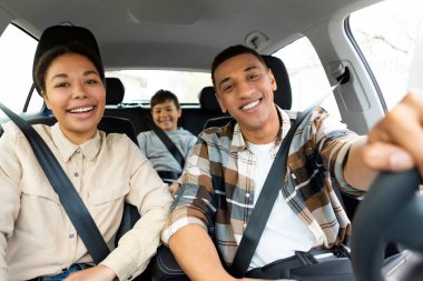 Üç kişilik mutlu bir aile, otomobille seyahat ediyorlar, aileleri ve oğulları yaz yolculuğunun keyfini çıkarıyorlar.