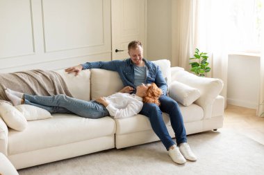 Mutlu çift haftasonunu evdeki kanepede dinlenerek, birlikte vakit geçirerek, kadının erkeğin kucağında yatarak geçiriyor.