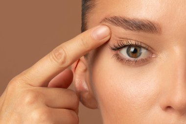 Avrupalı genç bir kadının göz kapağındaki kırışıklıkları göstermesi, dokunaklı bir yüz. Blepharoplasty konsepti