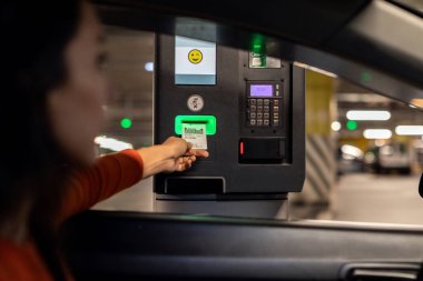 Bir kadın otoparka giriyor ve otopark otomatiklerinden trafik cezası alıyor.