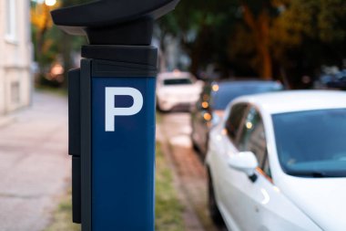 Bulanık arabalı şehir caddesinde mavi otomatik park cezası makinesi. Modern teknoloji kavramı