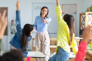 Sınıfta çeşitli çocuklar el kaldırıyor ve bayan öğretmenlere dikiz aynasından sorular soruyorlar. Okuldaki parlak çocuklar modern eğitim alıyorlar.