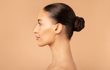 Burun estetiğinden önce burnu olan kadın profili, kadın burnunun tümseğinden estetik ameliyata hazırlanıyor. Burun boşluğunun düzeltilmesi