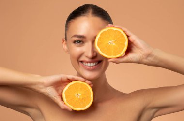 Cilt bakımının doğal C vitamini. Turunçgil meyvesi, dermatoloji ya da sağlıklı yaşam dilimleri olan mutlu bir kadın.