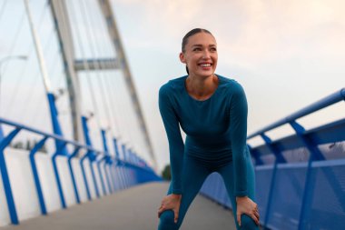 Mutlu Avrupalı atletik kadın akşamları şehirde antrenman yaparken nefes alıyor.