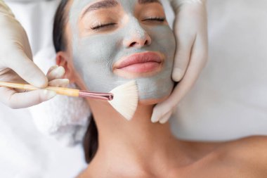 Yüz maskesi, kaplıca güzellik tedavisi ve cilt bakımı. Güzellik salonundaki kadın yüz bakımını alıyor. Yakın çekim.