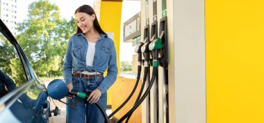 Modern benzin istasyonunda kadın otomobili biyo yakıtla dolduruyor. Çevre dostu ve elverişli araba bakımı, otomobil yakıtlı teklif kavramı