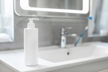 Banyoda leğen üzerine beyaz losyon kozmetik şişesi, marka tasarımı için kozmetik modelleme. Kişisel bakım ürünü