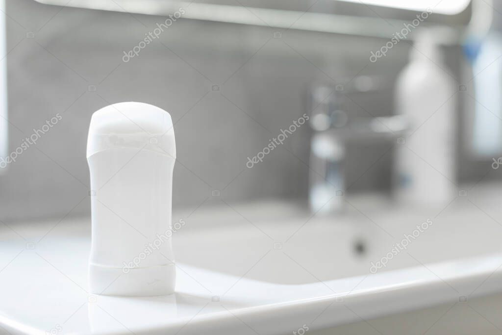 Blank stick deodorant on countertop in bathroom, mockup with copy space for brand design