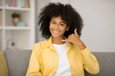 Hey sen, ara beni. Mutlu, genç, güzel bir kadın ev içi kameraya bakıp gülümsüyor.