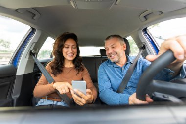 Doğru yolu gösteren olumlu bir kadın, cep telefonunda GPS uygulaması kullanıyor, eşleri seyahat ediyor ve araçla geziniyor.