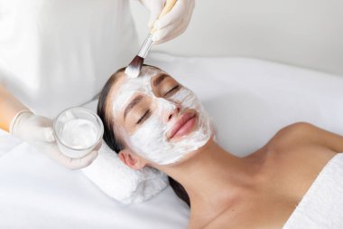 Yüz maskesinin tadını çıkarıyorum. Güzeller güzeli genç bir kadın güzellik salonunda maske takıyor.