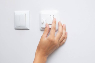 Işığı loş kolla ayarlayan kadın, yakın çekim. Elektrik gücünü değiştirmek için tasarlanmış bir elektronik cihaz.