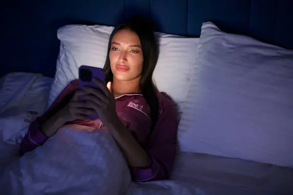 Genç ve güzel bir kadın gece geç saatlerde cep telefonu kullanıyor, uykusuzca yatakta yatıyor, internetteki randevu uygulamalarında mesajlaşıyor ya da sosyal ağlarda geziniyor, boş yer var.