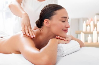 Spa salonundaki profesyonel masözden sırt ve omuz masajı alan mutlu Avrupalı bayan, kapalı gözlerle rahatlatıcı spa tedavisi görüyor.